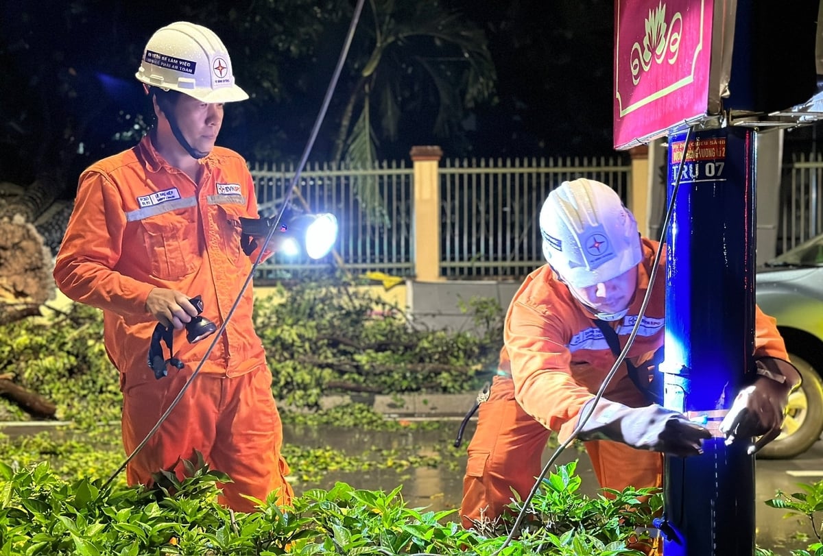 Công nhân điện lực phối hợp Ban Chỉ huy Quân sự xã Phú Giáo xử lý trụ điện và cành cây gãy đổ để đảm bảo an toàn cho người dân sau cơn dông lốc. Ảnh: Duy Minh.