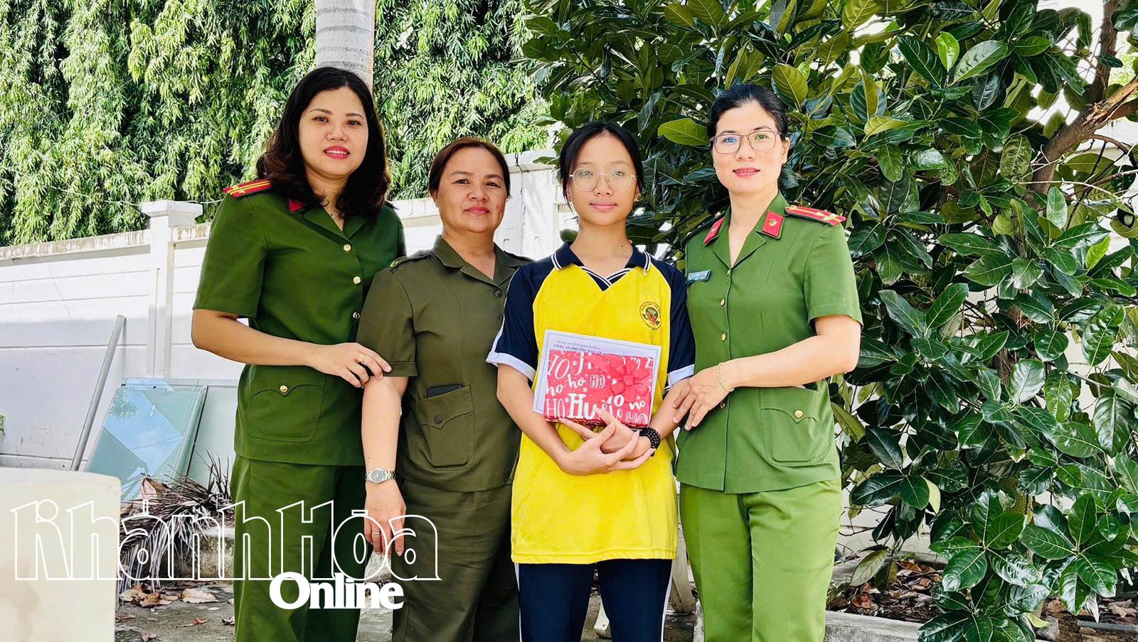 In the presence of Ms. Nguyen Thi Ngoc Trang, representative of the Women's Association of Bao An Ward Police presented a gift to Nguyen Ngoc Quynh Tram.