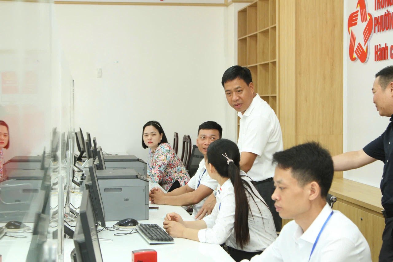 این فونگ وارڈ پیپلز کمیٹی کے چیئرمین لام وان ڈیٹ وارڈ کے پبلک ایڈمنسٹریشن سینٹر کے افسران کے ساتھ۔ (تصویر: ہائے انہ)