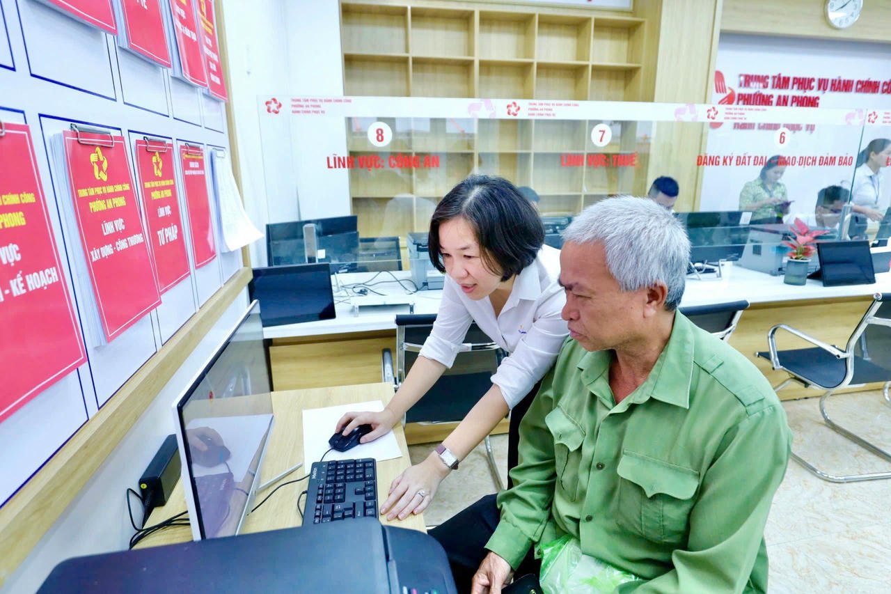 فوننگ وارڈ کے اہلکار آن لائن طریقہ کار کو مکمل کرنے کے لیے لوگوں کی رہنمائی کرتے ہیں۔ (تصویر: ہائے انہ)