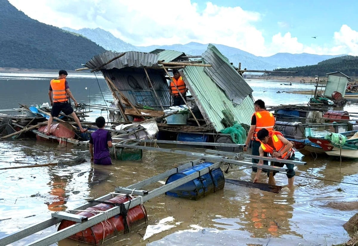 Lực lượng dân quân xã Vĩnh Thạnh giúp các hộ nuôi cá lồng bè trong lòng hồ Định Bình thu dọn sắt từ những ô lồng đã bung nát. Ảnh: V.Đ.T.