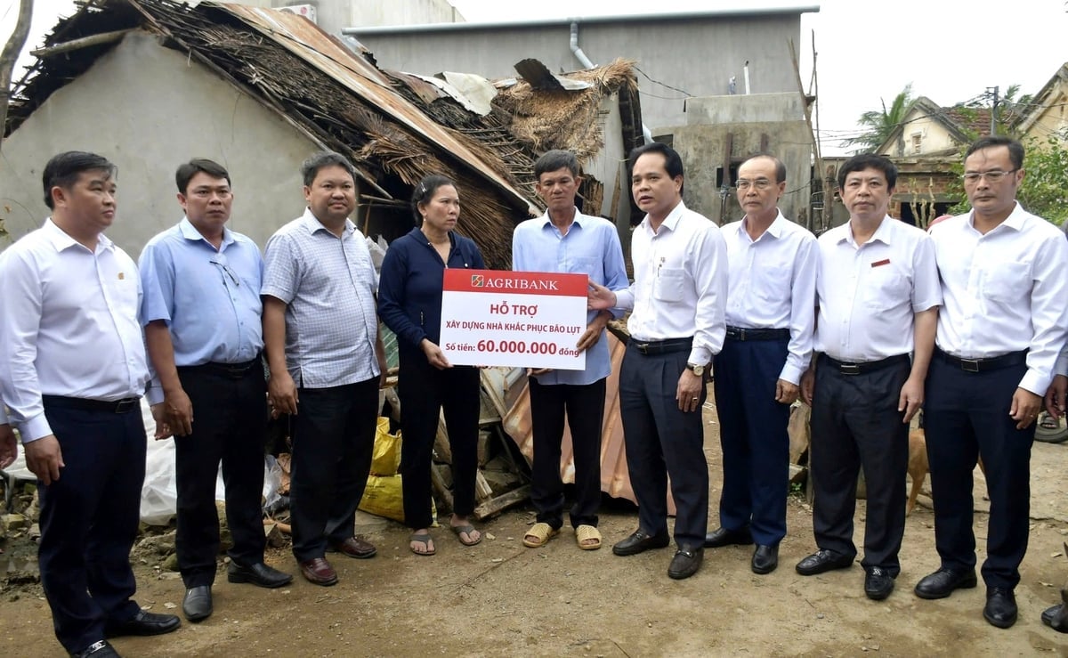 Ông Vương Hồng Lĩnh, Phó Tổng Giám đốc Agribank trao hỗ trợ cho người dân có nhà bị sập hoàn toàn do bão số 13. Ảnh: NH.