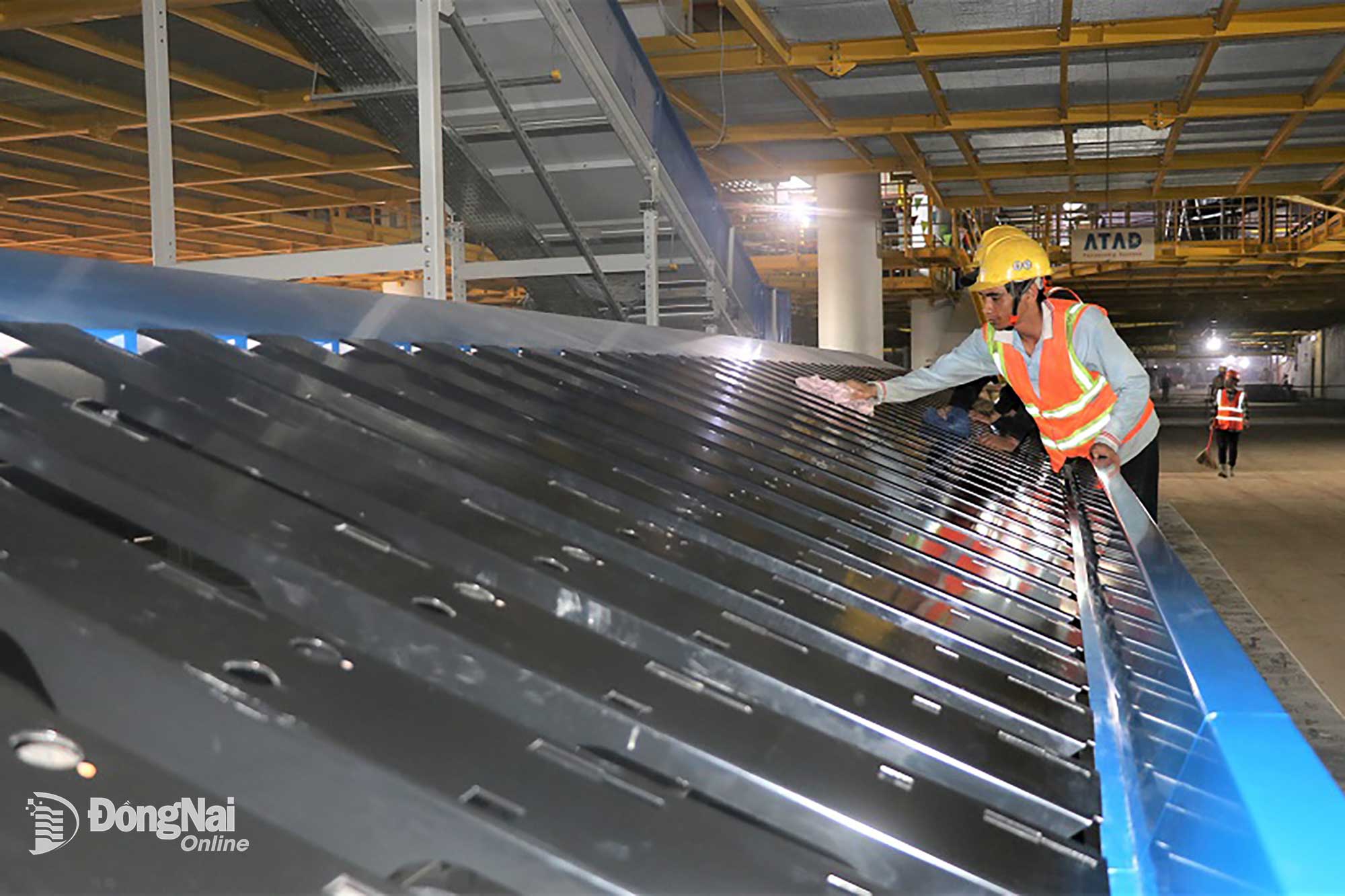 Arbetare rengör bagagehanteringssystemet efter att det installerats. Foto: Pham Tung