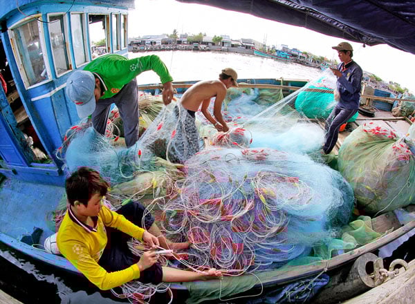 Vissers maken visgerei klaar om de zee op te gaan. Foto: BA THI