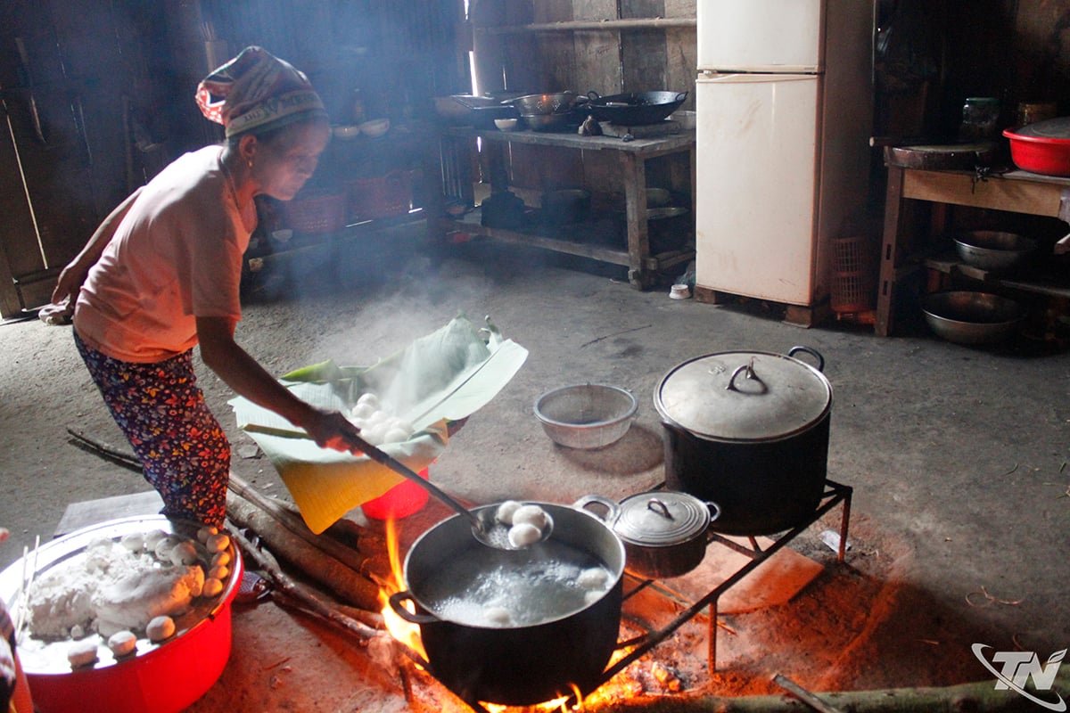 En Dao-etnisk kvinne i Yen Thinh-kommunen øser dyktig opp porsjoner med varm, nykokt banh troi.