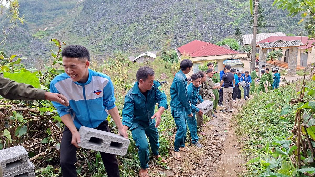 Ahli kesatuan belia komune Lung Phin menyokong orang ramai untuk mengalihkan rumah sementara.