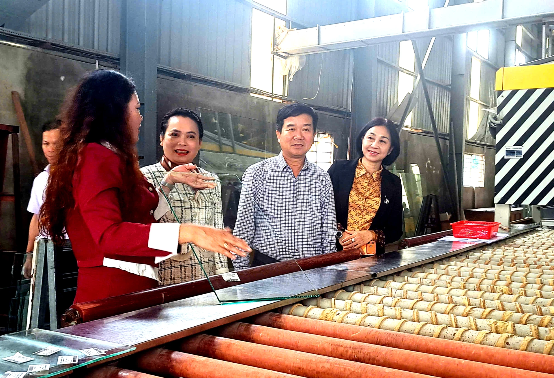 Đoàn công tác thăm nhà máy sản xuất kính cường lực tại Cụm công nghiệp Nghĩa Ninh. Ảnh: H.Tr