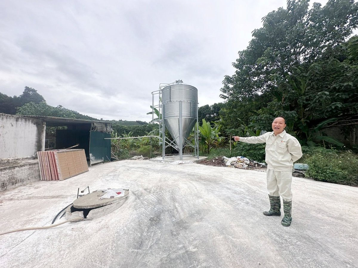 Nông dân Lê Đình Quý giới thiệu hệ thống thiết bị cho lợn ăn hiện đại, không dùng sức người của trang trại. Ảnh: Bích Hợp.