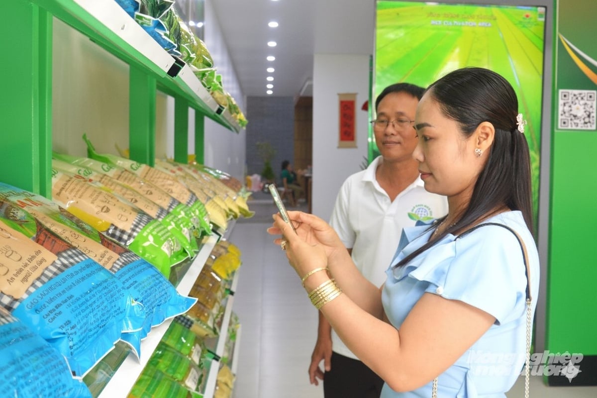 People in Rach Gia ward, An Giang province use smartphones to trace the origin of OCOP-standard rice. Photo: Trung Chanh. Người dân phường Rạch Giá, tỉnh An Giang sử dụng điện thoại thông minh để truy xuất nguồn gốc gạo đạt chuẩn OCOP. Ảnh: Trung Chánh.
