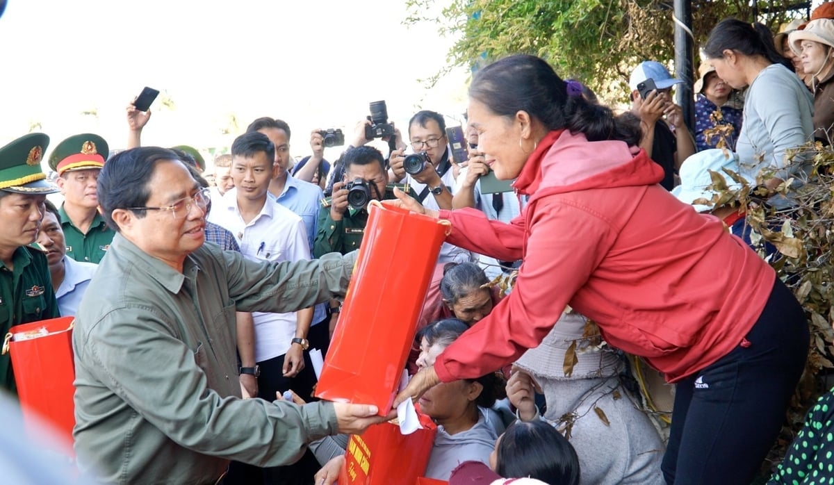 Thủ tướng Chính phủ Phạm Minh Chính tặng quà cho 26 hộ dân bị ảnh hưởng do triều cường tại thôn An Quang (xã Đề Gi, Gia Lai). Ảnh: Thu Loan.