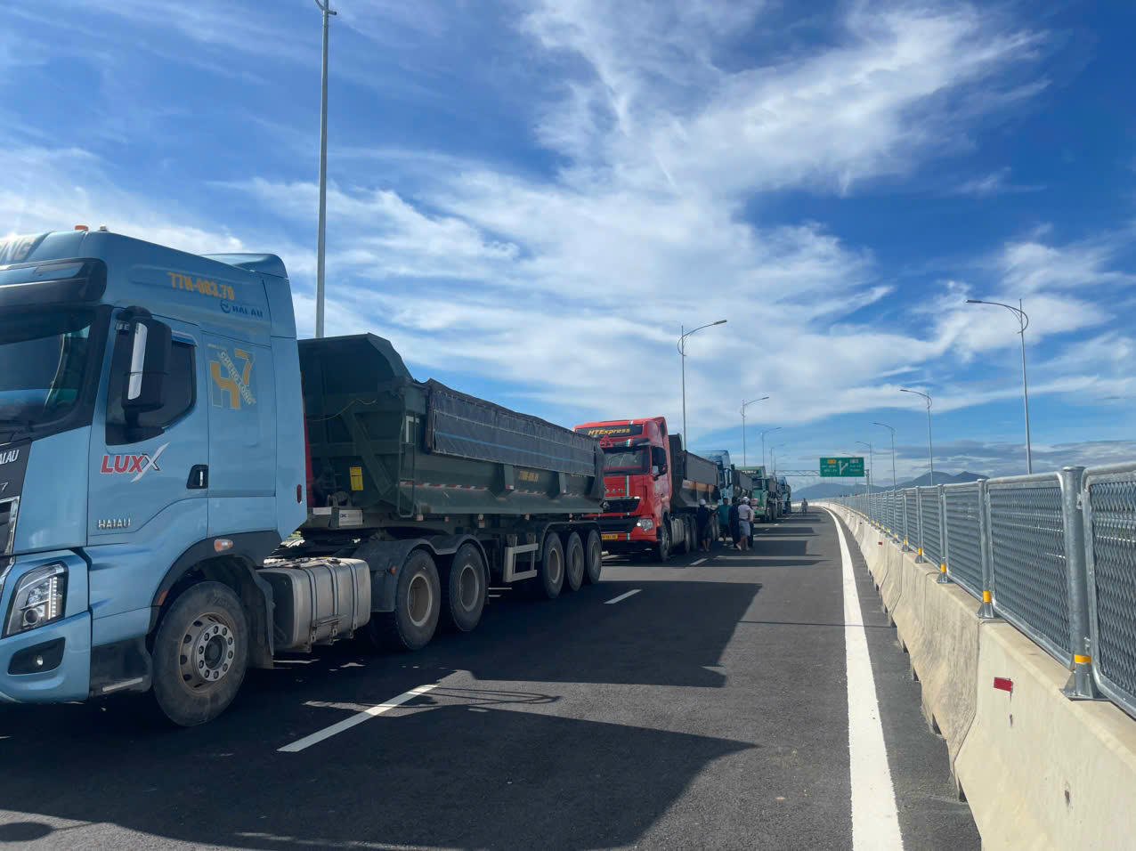 Грузовики, перевозящие грунт, обслуживают проект днем ​​и ночью.