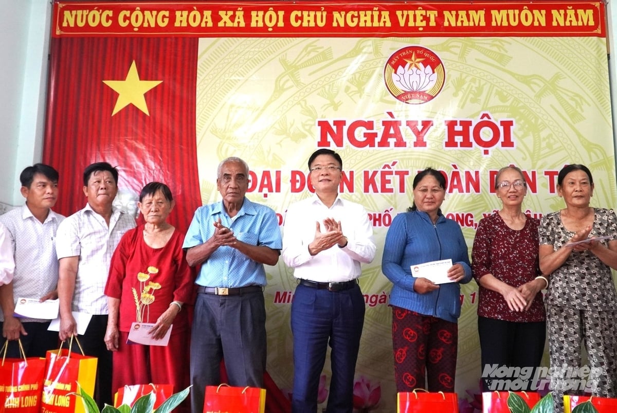 Phó Thủ tướng Chính phủ Lê Thành Long tặng quà cho các hộ gia đình chính sách tiêu biểu tại Ngày hội đại đoàn kết toàn dân tộc ở khu phố Minh Long, xã Châu Thành. Ảnh: Trung Chánh.