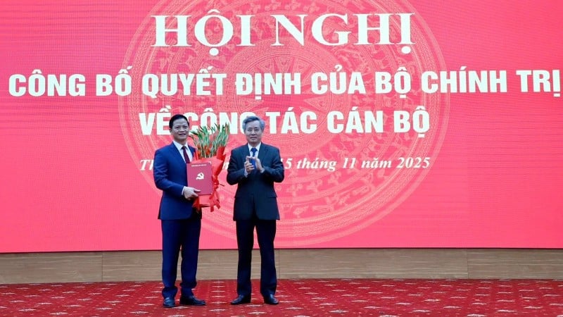 Kamrat Nguyen Quang Duong, biträdande chef för den centrala organisationskommittén (höger), presenterade beslutet och överlämnade blommor för att gratulera kamrat Vuong Quoc Tuan. (Foto: TUAN SON)