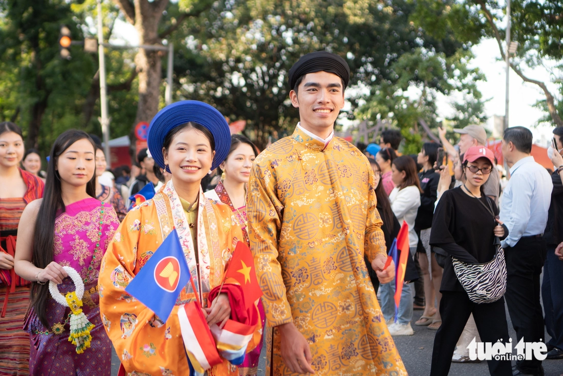 Utländska turister var förbluffade över paraden med ao dai och traditionella dräkter på gågatan vid Hoan Kiem-sjön - Foto 1. áo dài - Ảnh 1.