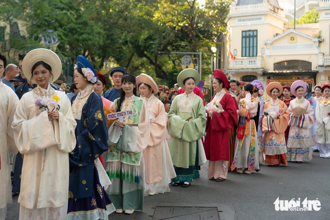 Utländska turister var förbluffade över paraden med ao dai och traditionella dräkter på gågatan vid Hoan Kiem-sjön - Foto 2. áo dài - Ảnh 2.