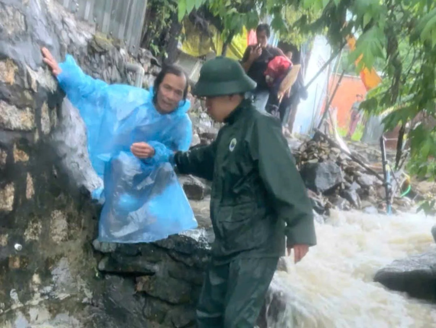 Cán bộ, chiến sĩ Đồn Biên phòng Cửa khẩu cảng Nha Trang đưa người dân ra khỏi vùng nguy cơ sạt lở.