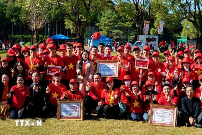 Kiều bào cùng nhau chụp ảnh sau khi xác lập kỷ lục. (Ảnh: Xuân Giao/TTXVN)