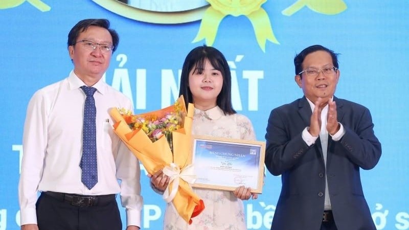 អ្នកនិពន្ធ Hoang Nguyen Van Nhi (កណ្តាល) ទទួលបានជ័យលាភីលេខ១ ក្នុងកម្មវិធីប្រឡងសរសេរ “គ្រូបង្រៀនជាទីគោរពស្រឡាញ់” ជាមួយនឹងស្នាដៃ “គ្រូបង្រៀនទីក្រុងហូជីមិញ ខំប្រឹងកាន់សៀវភៅឡើងភ្នំ”។