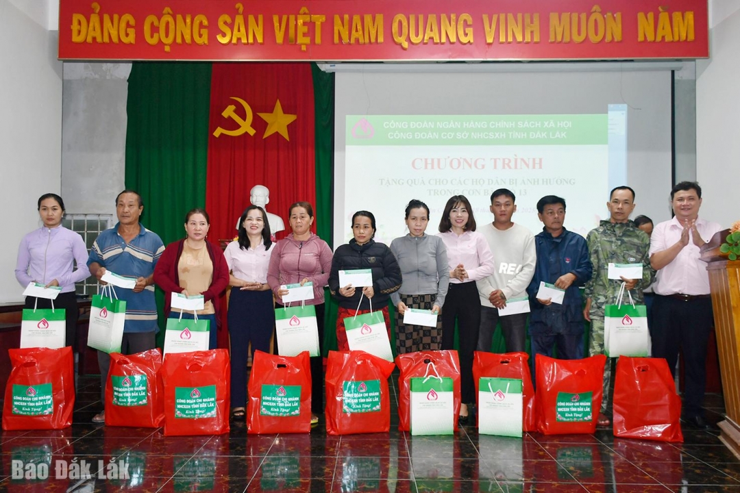 Đại diện Công đoàn cơ sở Chi nhánh NHCSXH tỉnh Đắk Lắk trao quà cho người dân xã Xuân Cảnh.