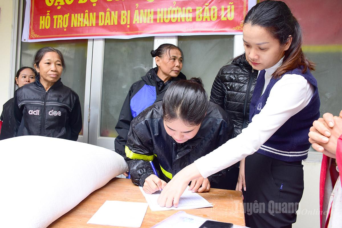 ប្រជាពលរដ្ឋចុះហត្ថលេខា និងពិនិត្យអង្ករមុនពេលទទួលបានអង្ករសង្គ្រោះ។