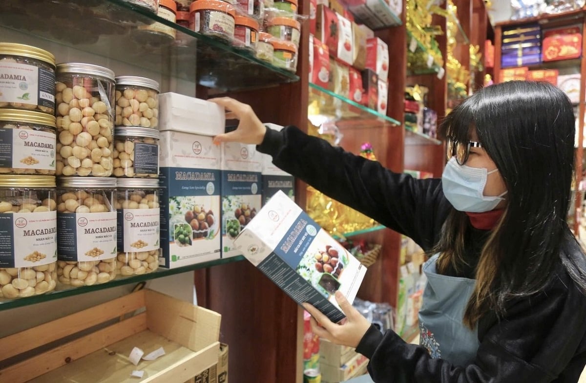 Nhân viên một cửa hàng sắp xếp các hộp macca Minh Cường trên quầy trưng bày. Ảnh: Minh Cường.