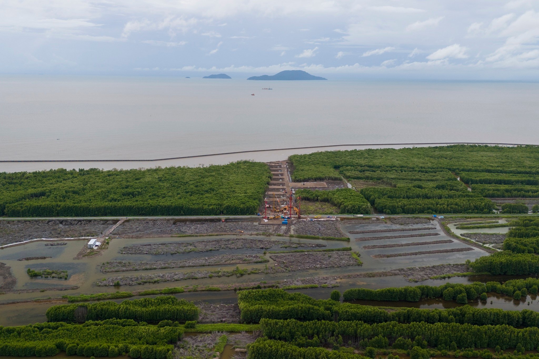 カマウ・ダットムイ高速道路との接続地点には、請負業者によって多くの建設機械や設備が集められていました。 Tại điểm kết nối với cao tốc Cà Mau - Đất Mũi, nhiều máy móc, thiết bị thi công đã được nhà thầu tập kết.