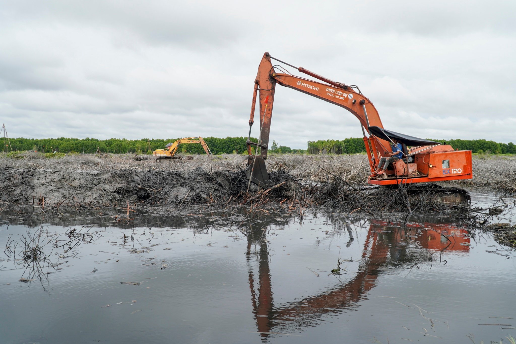 建設工事の整地作業を専門の機械で行っています。 Máy móc chuyên dụng đang triển khai công tác san lấp mặt bằng phục vụ thi công.