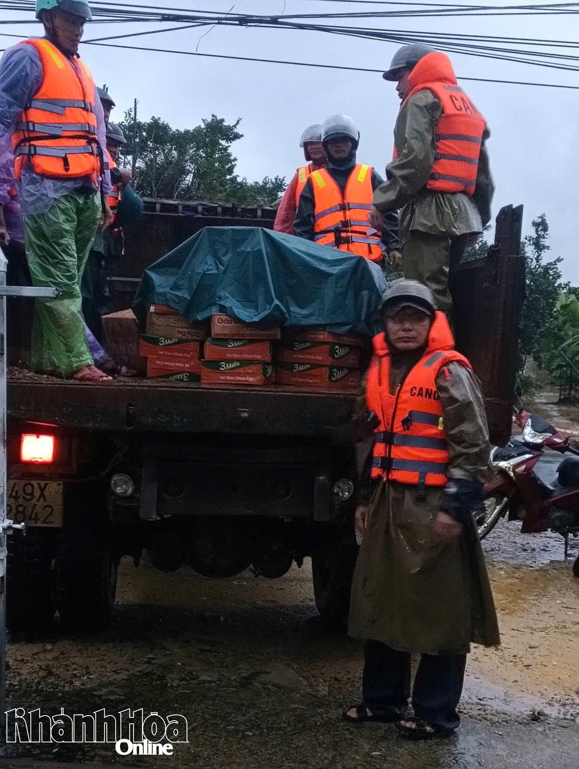 Lực lượng chức năng xã Trung Khánh Vĩnh hỗ trợ nhu yếu phẩm cho người dân ở vùng chia cắt do mưa lũ.