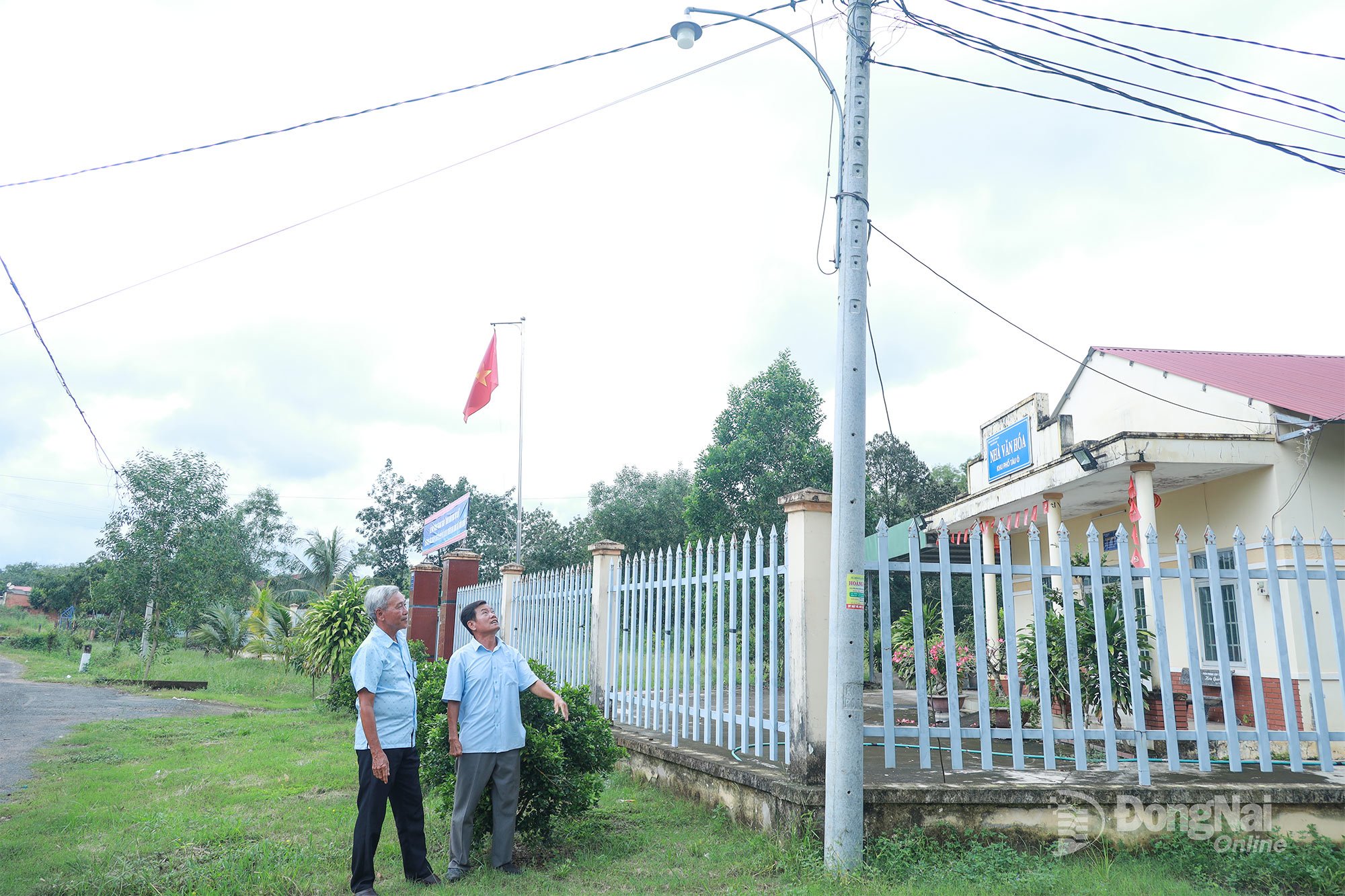 Ông Huỳnh Văn Giỏi (phải, ngụ thôn Tàu Ô, xã Tân Khai) xem lại hệ thống đèn chiếu sáng trên các tuyến đường do ông và người dân chung sức lắp đặt. Ảnh: Diệu Lan