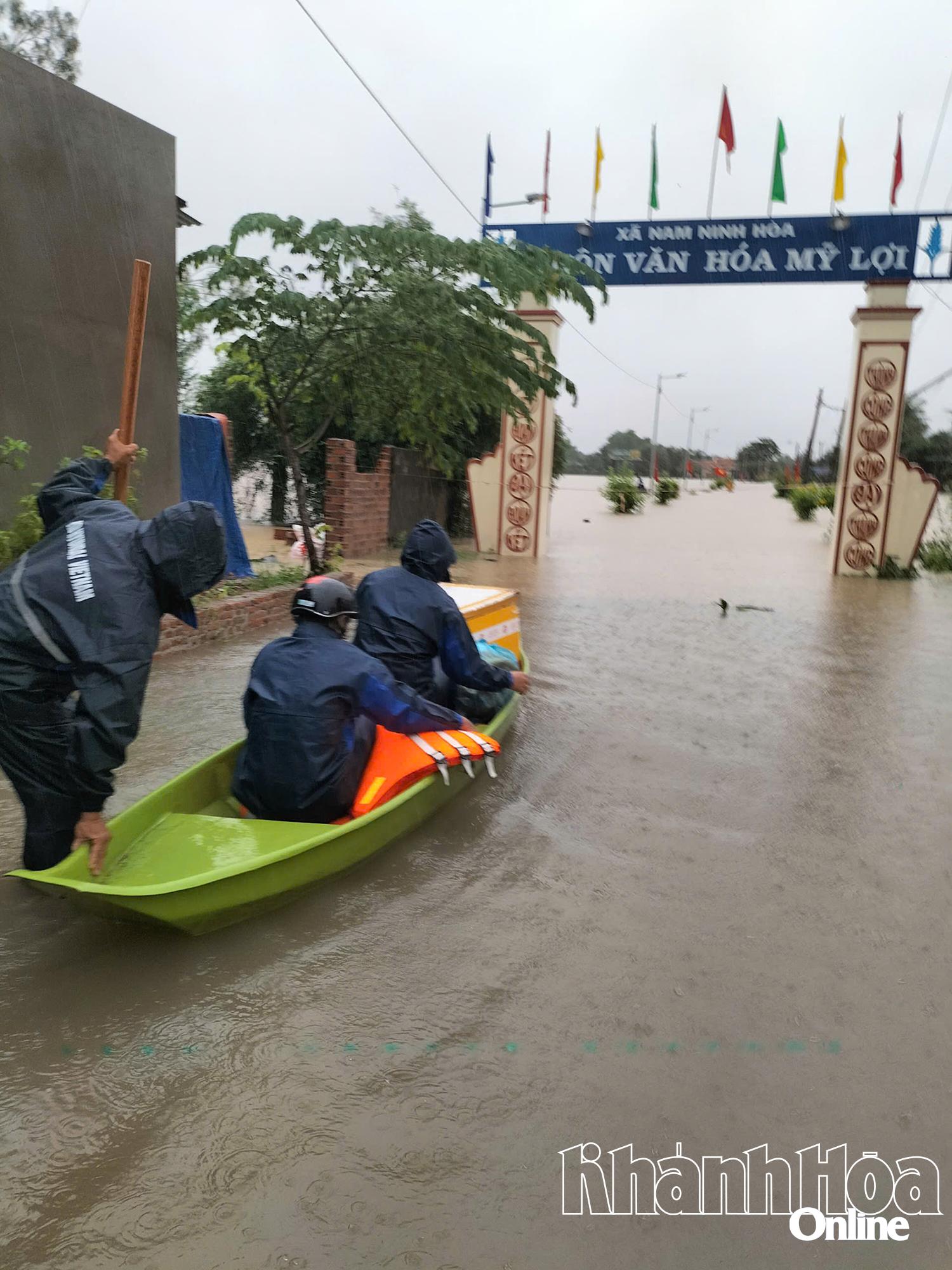 Lực lượng chức năng xã Nam Ninh Hòa sử dụng xuồng nhỏ tiếp cận khu vực ngập do mưa lũ.