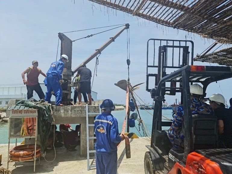 Technický personál servisního střediska technické logistiky ostrova Truong Sa přiváží na břeh k opravě vrtuli rybářského člunu, který měl problém. (Foto: QUANG DAO)