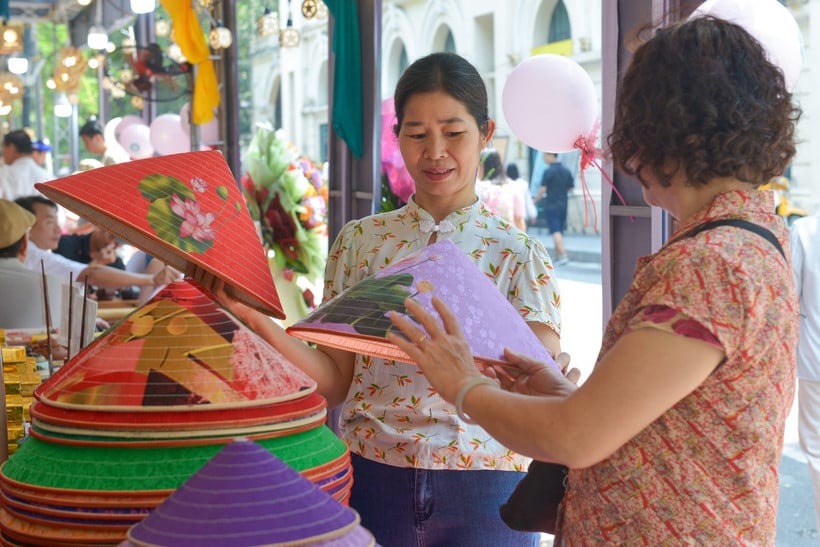 Turyści podziwiają stożkowate kapelusze w wiosce rzemieślniczej Chuong (dzielnica Thanh Oai, Hanoi) w ramach 2. Jesiennego Festiwalu w Hanoi w 2024 r. (Zdjęcie: THE DAI)