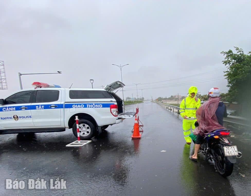 Lực lượng CSGT tổ chức chốt chặn trên tuyến quốc lộ 29 để ngăn chặn người dân đi vào vùng nước ngập.