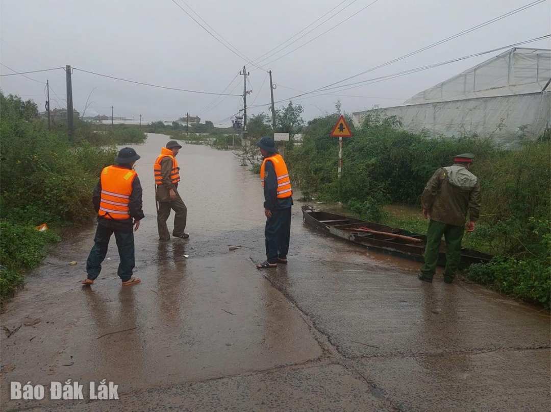 Myndigheterna kontrollerar och bevakar det djupt översvämmade området på vägen Dak Rơleang 2 mellan byarna till Kon Hring.