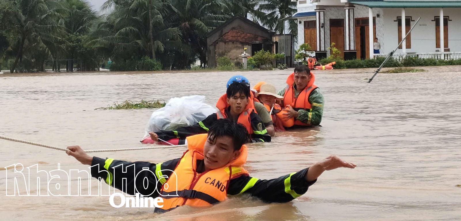 Các chiến sĩ cứu nạn, cứu hộ sử dụng dây thừng, giúp người dân ở thôn Mỹ Lợi, xã Nam Ninh Hòa thoát khỏi vùng nước lũ