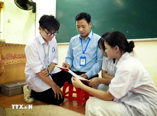 Sau tiết học, thầy Tuyến vẫn giành thời gian trò chuyện thân thiết với học trò, tạo mối quan hệ ấm áp và gần gũi. (Ảnh: Hoàng Hùng/TTXVN)