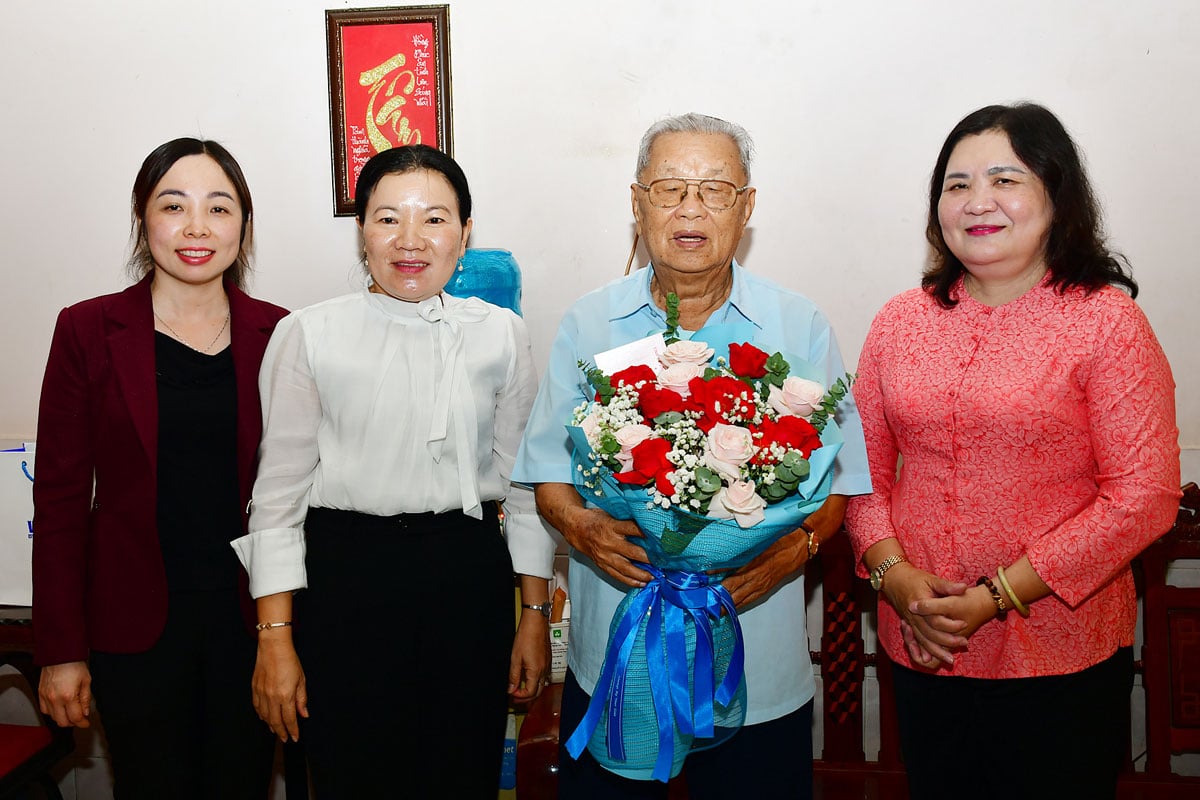 A camarada Ho Thi Hoang Yen, Secretária Adjunta Permanente do Comitê Provincial do Partido (à direita), ofereceu flores para parabenizar o camarada Nguyen Ba Hieu.
