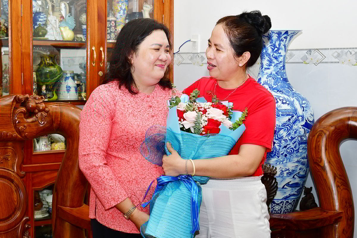 A camarada Ho Thi Hoang Yen, Secretária Adjunta Permanente do Comitê Provincial do Partido (à esquerda), ofereceu flores para parabenizar a camarada Nguyen Thi Bach Van.