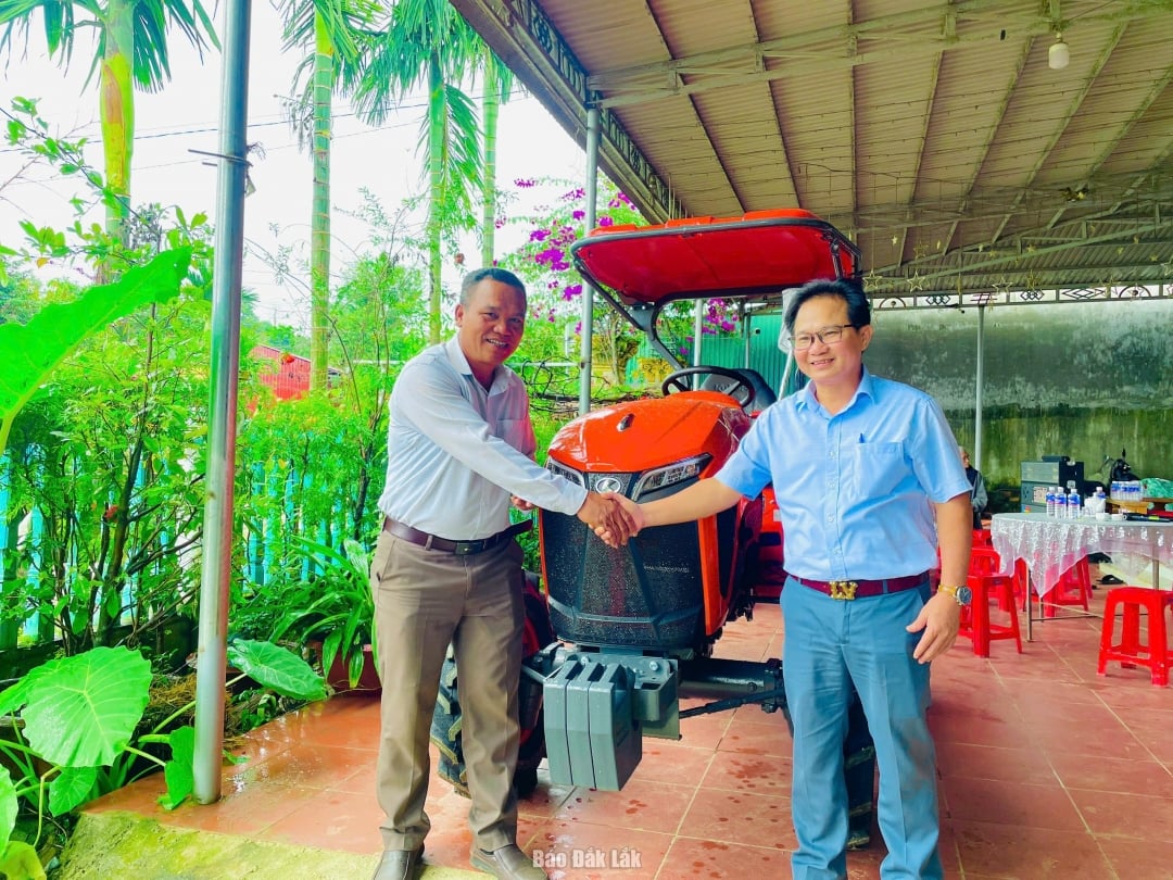 Đại diện Chi cục Phát triển nông thôn (bên phải) bàn giao máy kéo 4 bánh cho HTX Thiên Phú.