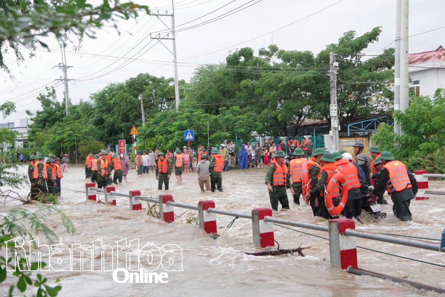 Soldater fra Brigade 5 støtter folk i Ninh Hai-kommunen gjennom oversvømte områder.
