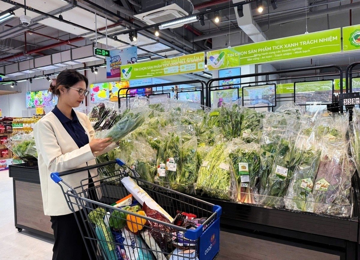 Người tiêu dùng tra cứu thông tin sản phẩm đạt 'Tick xanh trách nhiệm' tại siêu thị. Ảnh: Co.opmart - Bạn của mọi nhà.