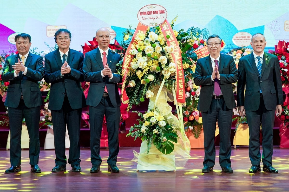 Thứ trưởng Hoàng Trung tặng hoa chúc mừng của Bộ Nông nghiệp và Môi trường tới tập thể Trường Đại học Thủy lợi. Ảnh: Bảo Thắng.