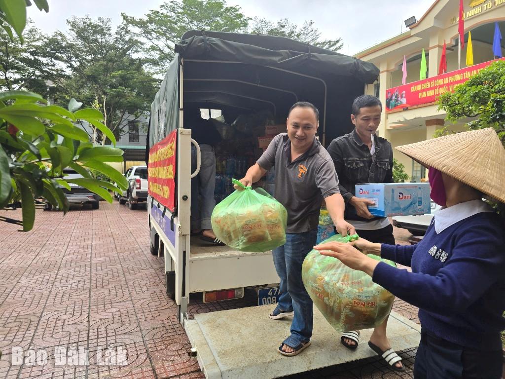 Mensen helpen slachtoffers van de overstroming met essentiële voorzieningen op het politiebureau in Tan An Ward.