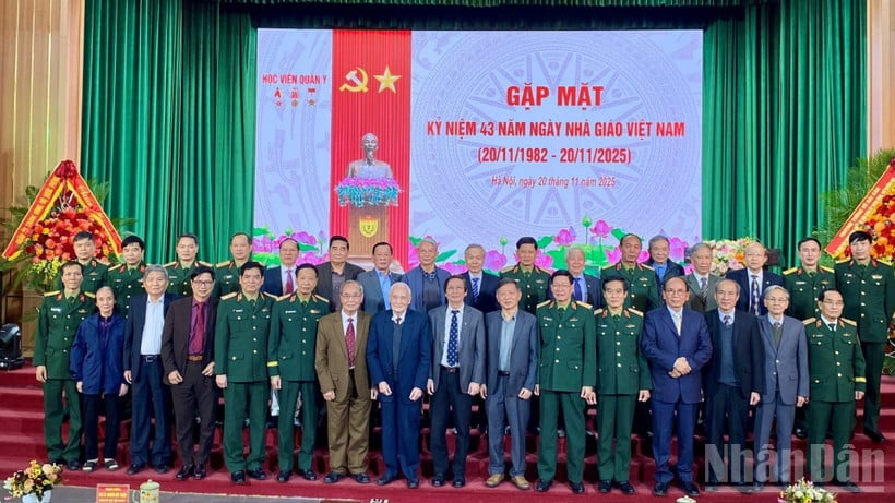 Delegater tar et gruppebilde på møtet for å feire 43-årsjubileet for Vietnams lærerdag. (Foto: DO THOA)