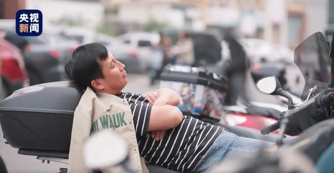 Một tài xế ở Sơn Tây tranh thủ ngủ trưa trên xe. Ảnh: YBWC News