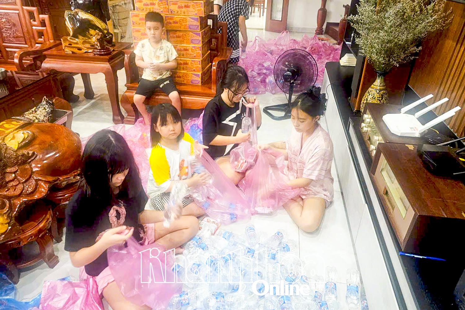 កុមារនៅវួដ Nam Nha Trang ចូលរួមក្នុងការវេចខ្ចប់ទំនិញ ដើម្បីជួយដល់ប្រជាជននៅតំបន់ទឹកជំនន់ធ្ងន់ធ្ងរ។