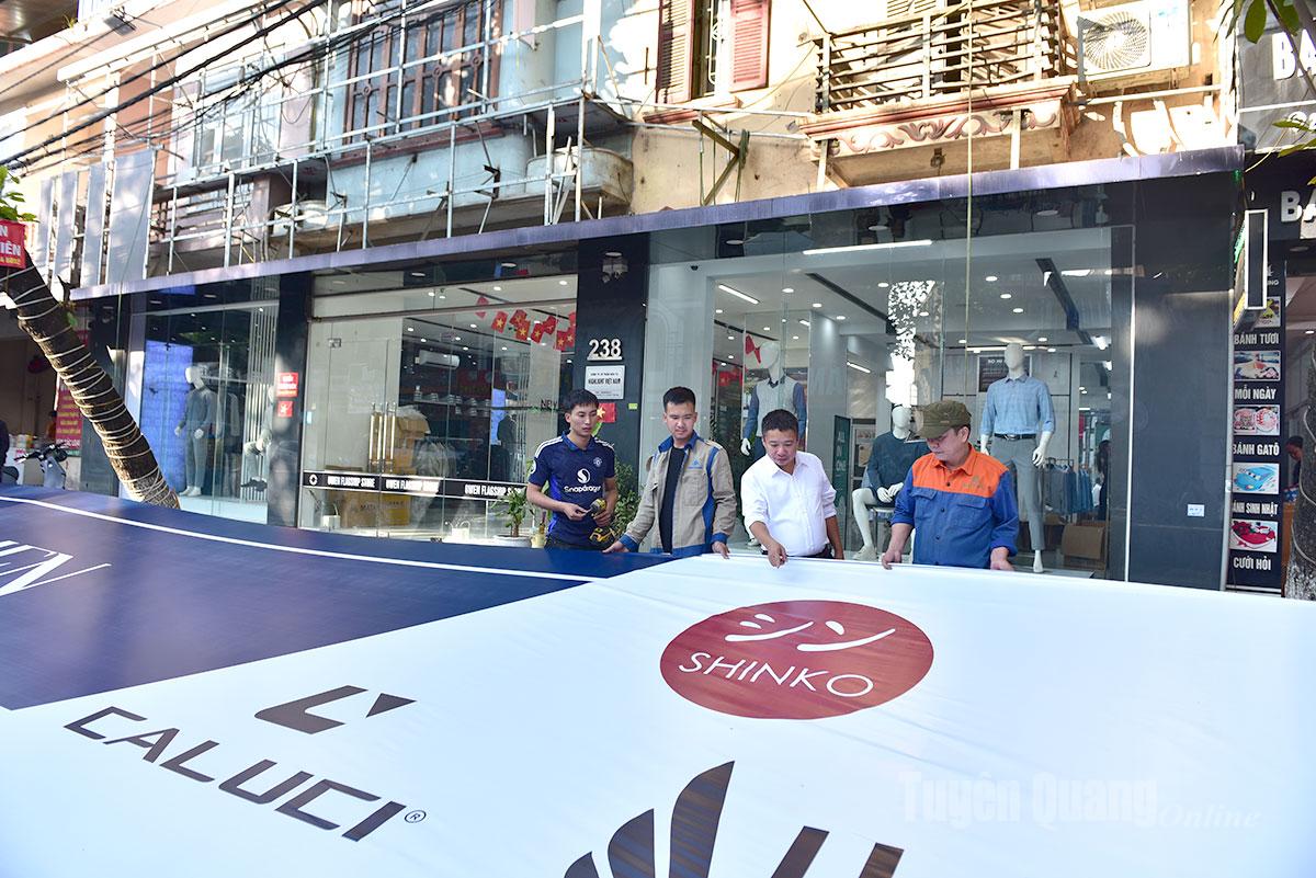 ທ່ານ ຫງວຽນ​ວັນ​ຕວນ ກວດກາ ​ແລະ ຊີ້​ນຳ​ພະນັກງານ​ກໍ່ສ້າງ​ປ້າຍ​ໂຄສະນາ​ໃຫ້​ແກ່​ລູກ​ຄ້າ.