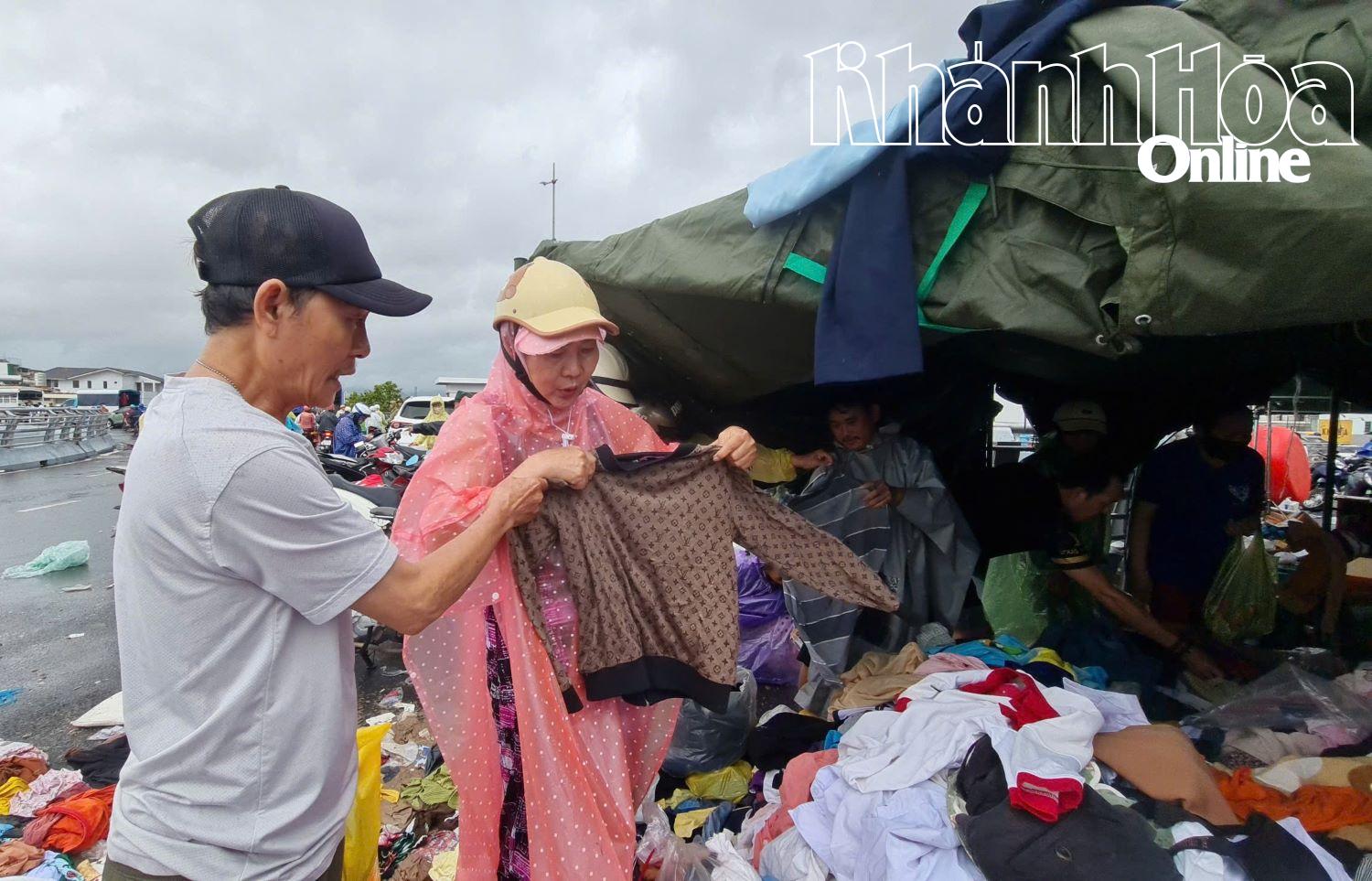 An einer Versorgungsstation suchen sich die Menschen trockene Kleidung zum Umziehen aus.