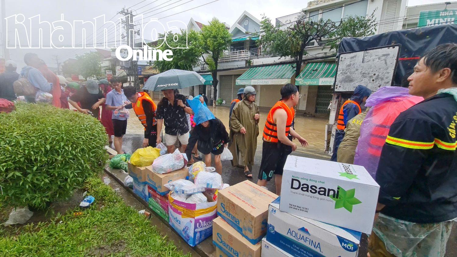 An einer Ausgabestelle einer Freiwilligengruppe erhalten die Menschen Essen und Getränke.
