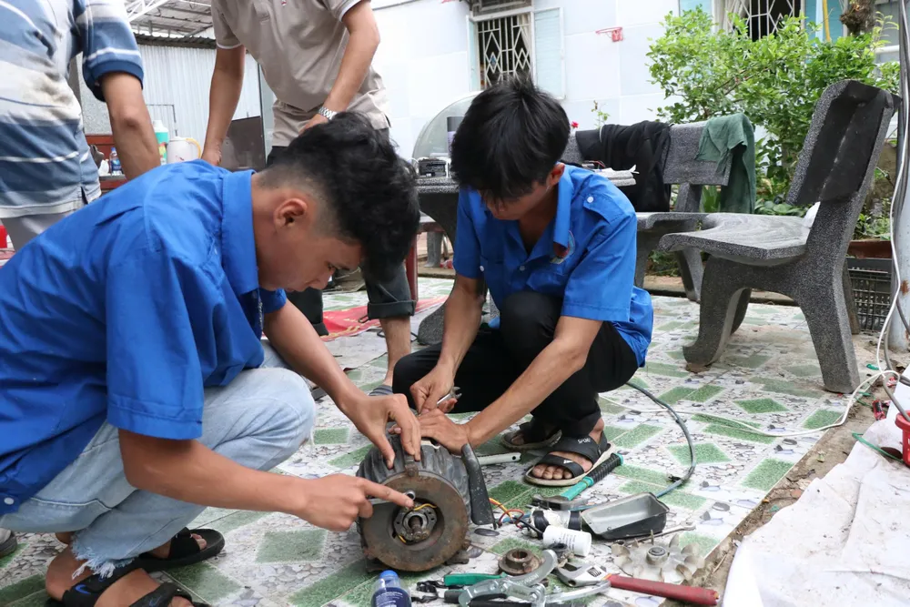 Các sinh viên sửa chữa thiết bị điện bị hư hỏng cho người dân sau mưa lũ